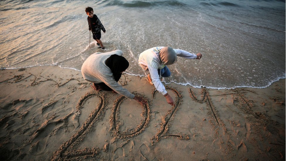 Getty Images | فتاتان من غزة تخطان اسم العام الجديد على شاطئ البحر
