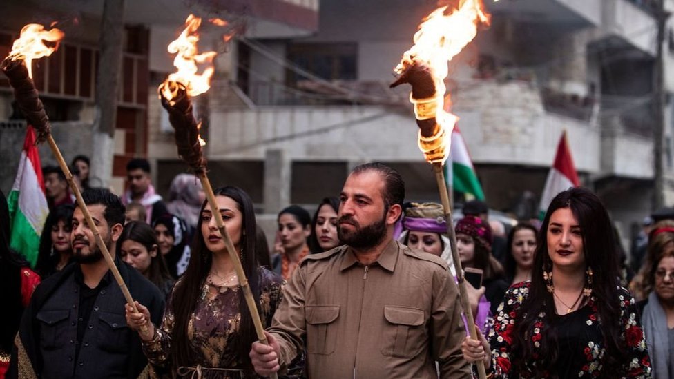 أكراد يحملون المشاعل في ليلة نوروز، في مدينة القامشلي، شمال شرقي سوريا. 20.03.2021