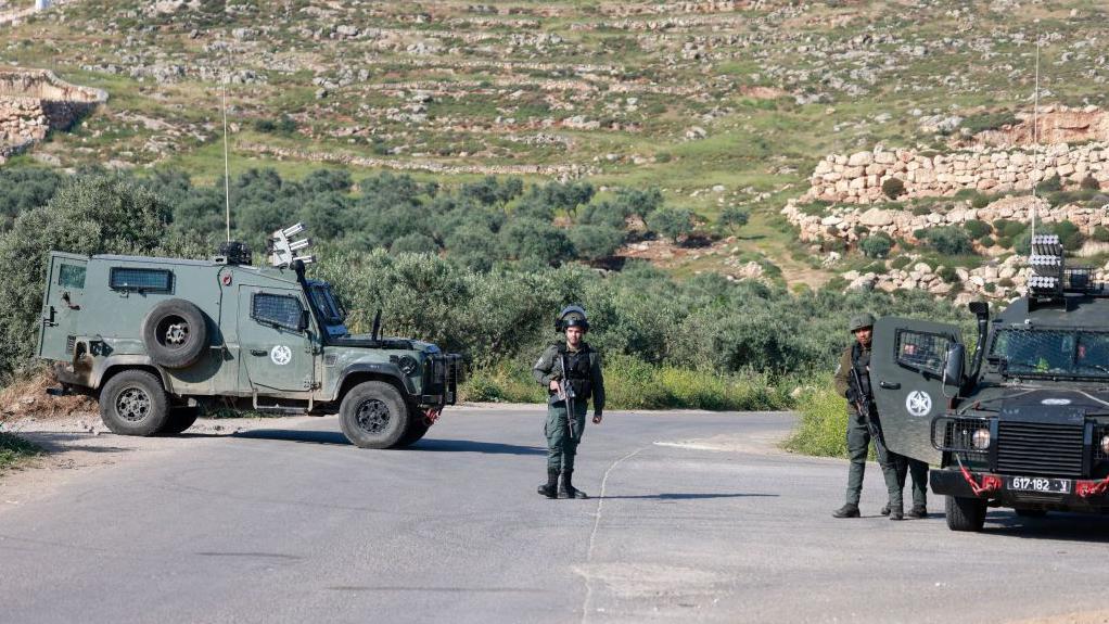 قوات إسرائيلية تحرس نقطة تفتيش أثناء البحث عن الصبي الإسرائيلي المفقود في بلدة المغير بالقرب من رام الله في الضفة الغربية.