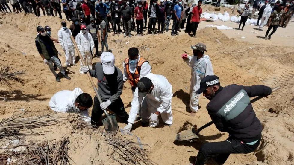 عمال فلسطينيون يستخرجون الجثث في مستشفى ناصر
