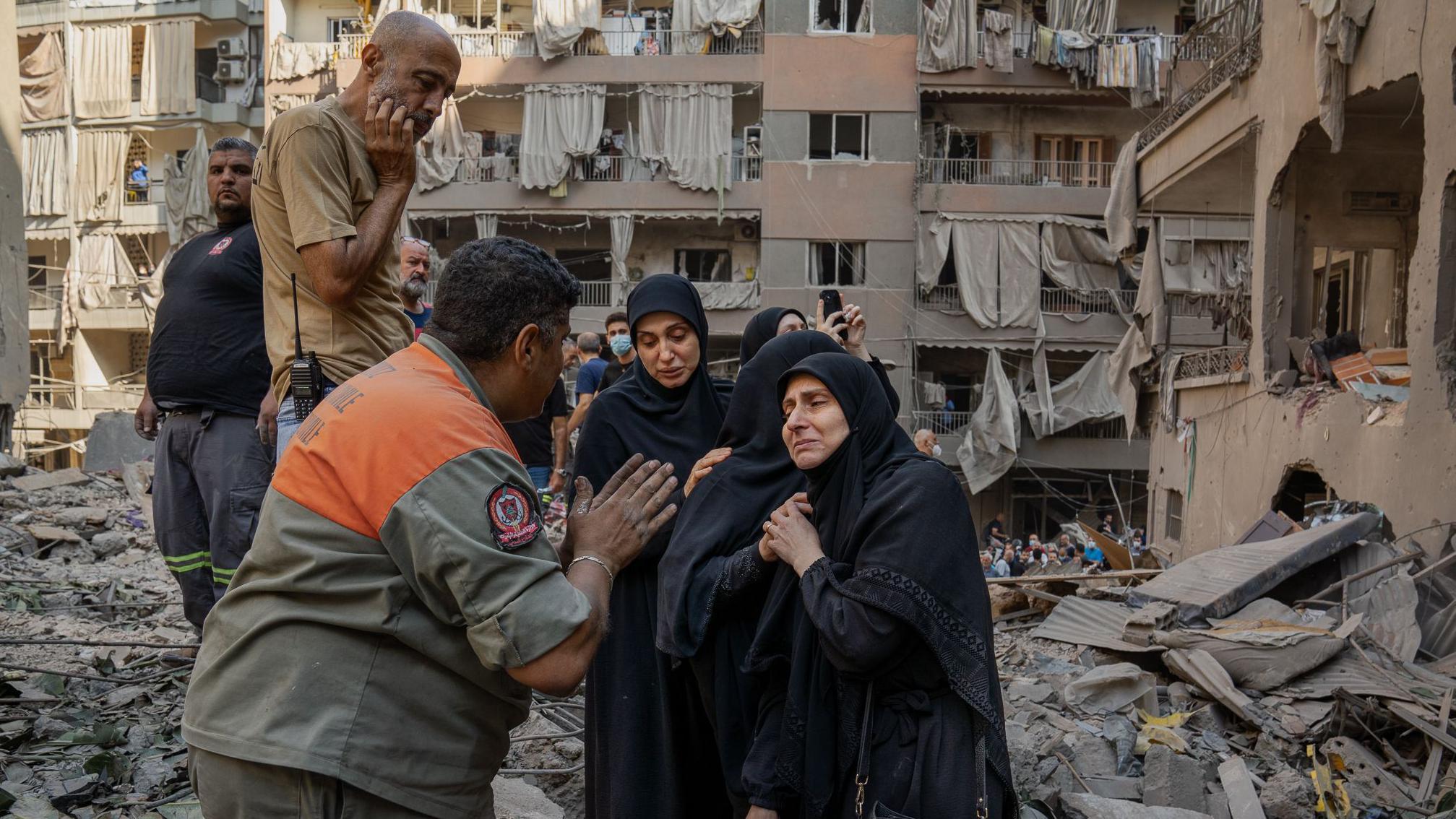 سكان مصدومون يتحدثون مع يوسف الملاح، رئيس فريق الإنقاذ، في موقع غارة البسطة في بيروت