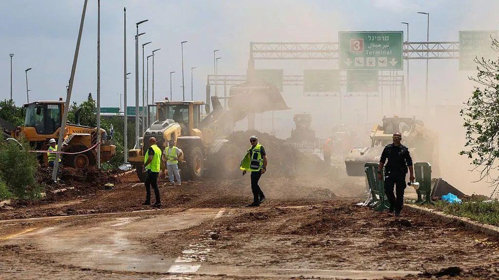السلطات تقوم بتنظيف طريق بجوار موقع سقوط صاروخ في محيط مطار بن غوريون - Getty Images