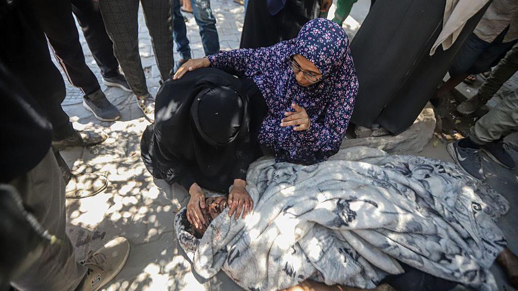 جثث فلسطينيين قتلوا في غارة جوية إسرائيلية على محطة شحن الهواتف المحمولة في حي الشيخ رضوان يتم نقلها إلى مستشفى الشفاء لإجراءات الجنازة في مدينة غزة، غزة - Getty Images