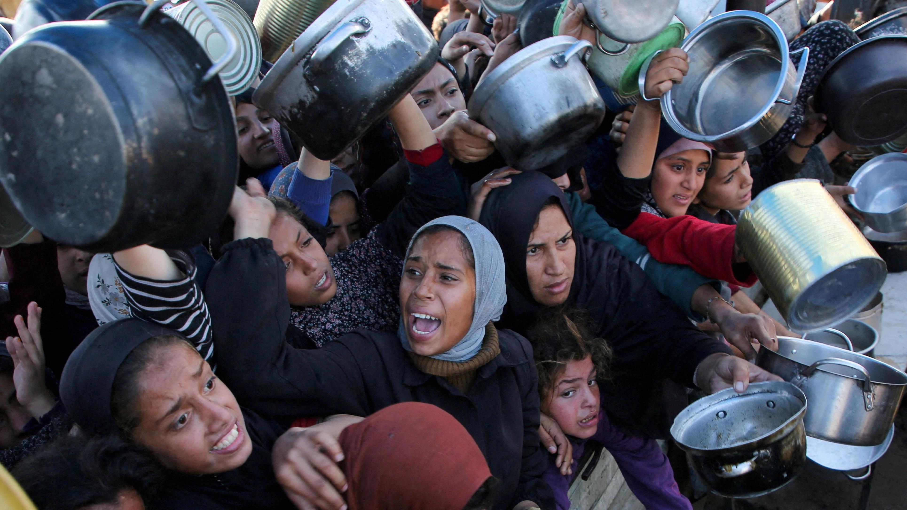 فلسطينيون يحاولون الحصول على طعام في ظل أزمة الغذاء التي يعيشها قطاع غزة جراء استمرار الحرب - Reuters