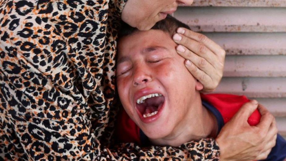 الأم الفلسطينية سماح النوري، التي فقدت ابنتها سما في غارة إسرائيلية يوم الخميس قرب مركز طبي في دير البلح، تعزي ابنها. - Reuters