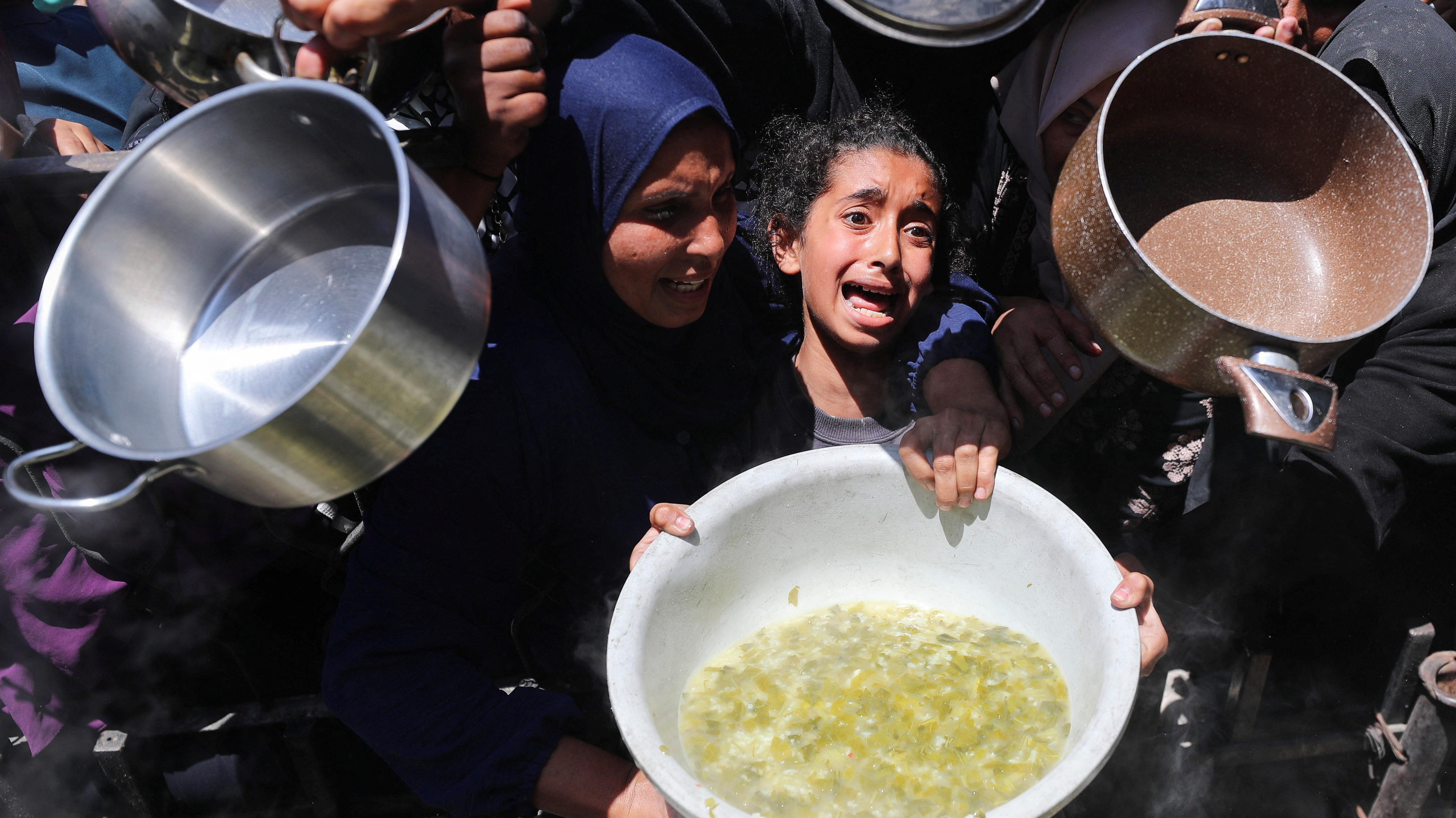 فتاة تبكي، بينما ينتظر فلسطينيون الحصول على طعام مطبوخ في مطبخ خيري، في بيت لاهيا، شمال قطاع غزة - Reuters