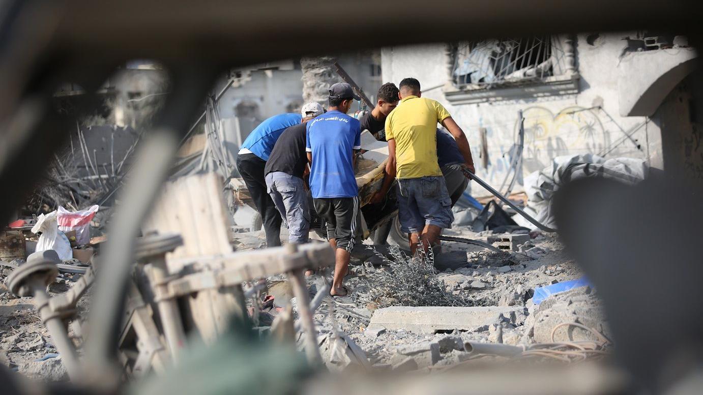 فلسطينيون يبحثون بين أنقاض منازلهم المدمرة عن أي ممتلكات يمكن استخدامها بعد غارة جوية إسرائيلية استهدفت عدة منازل في مخيم جديد شمال غرب النصيرات بقطاع غزة في 29 يوليو/تموز 2025. دُمرت عدة منازل بالكامل في الهجوم، الذي أسفر عن مقتل العديد من الفلسطينيين - Getty Images