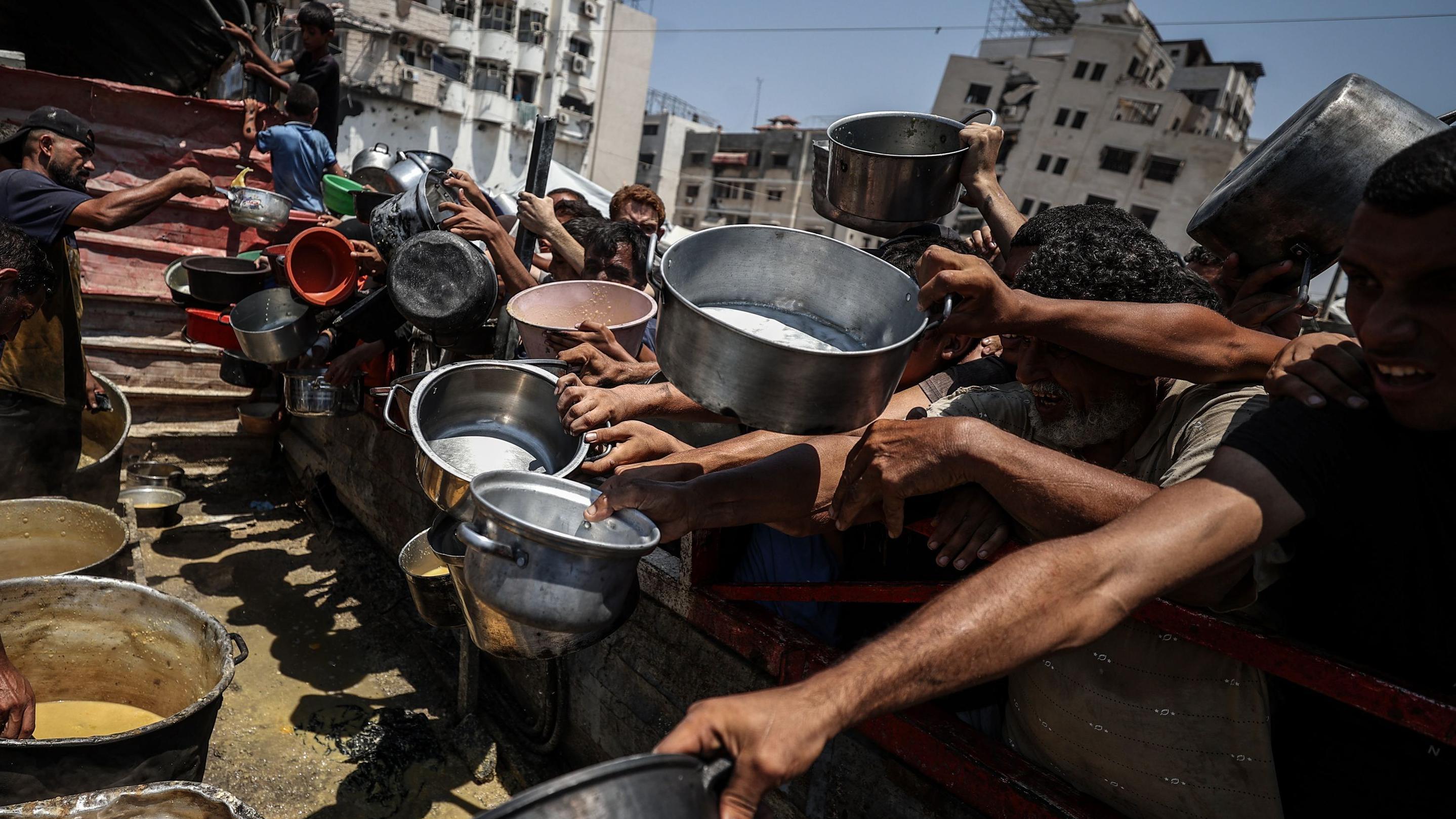 توزيع غذاء على فلسطينيين في غزة وسط تحذيرات من مجاعة في القطاع المدمر - Getty Images