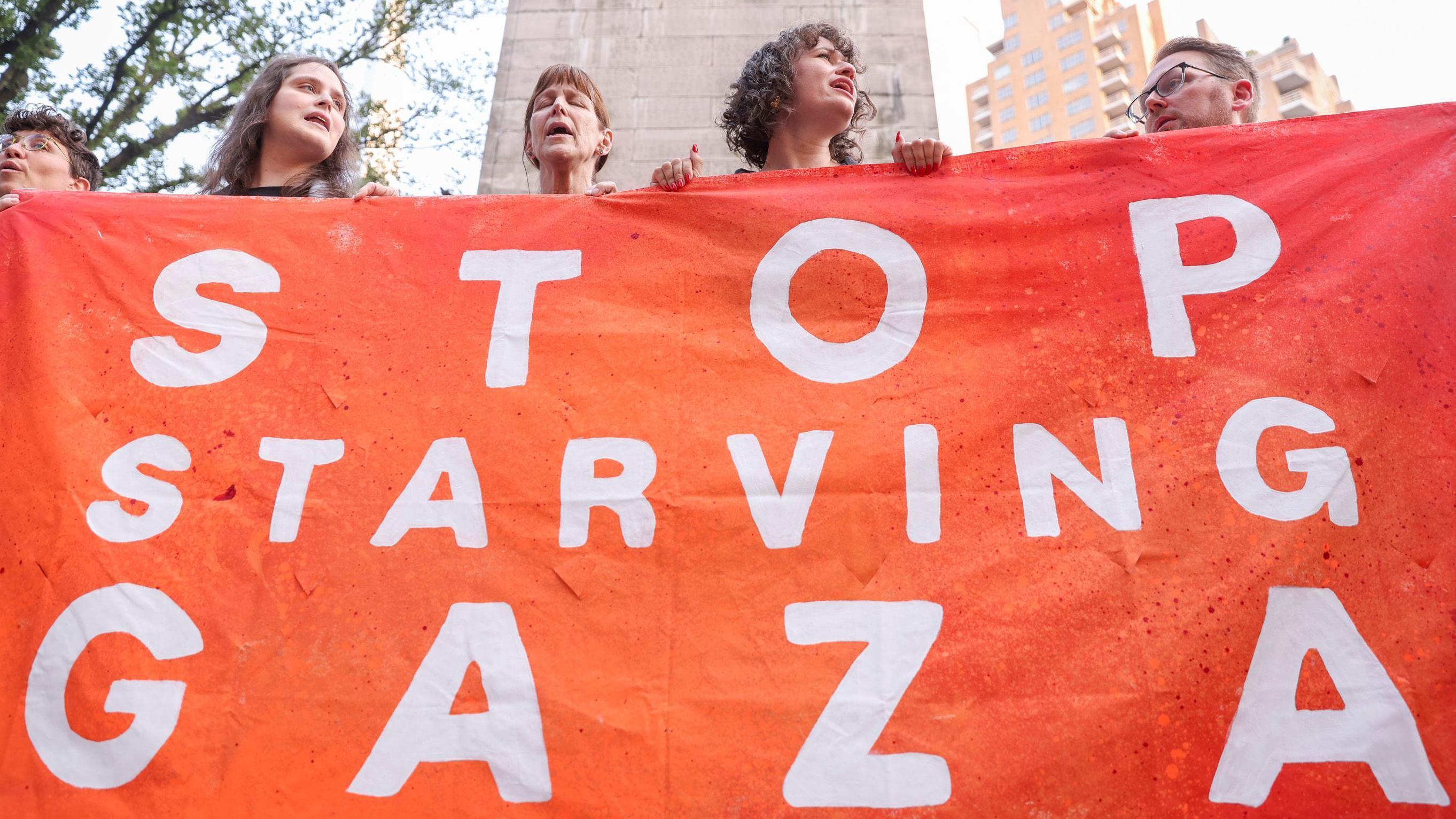 لافتة في نيويورك تطالب بوقف تجويع سكان غزة - EPA