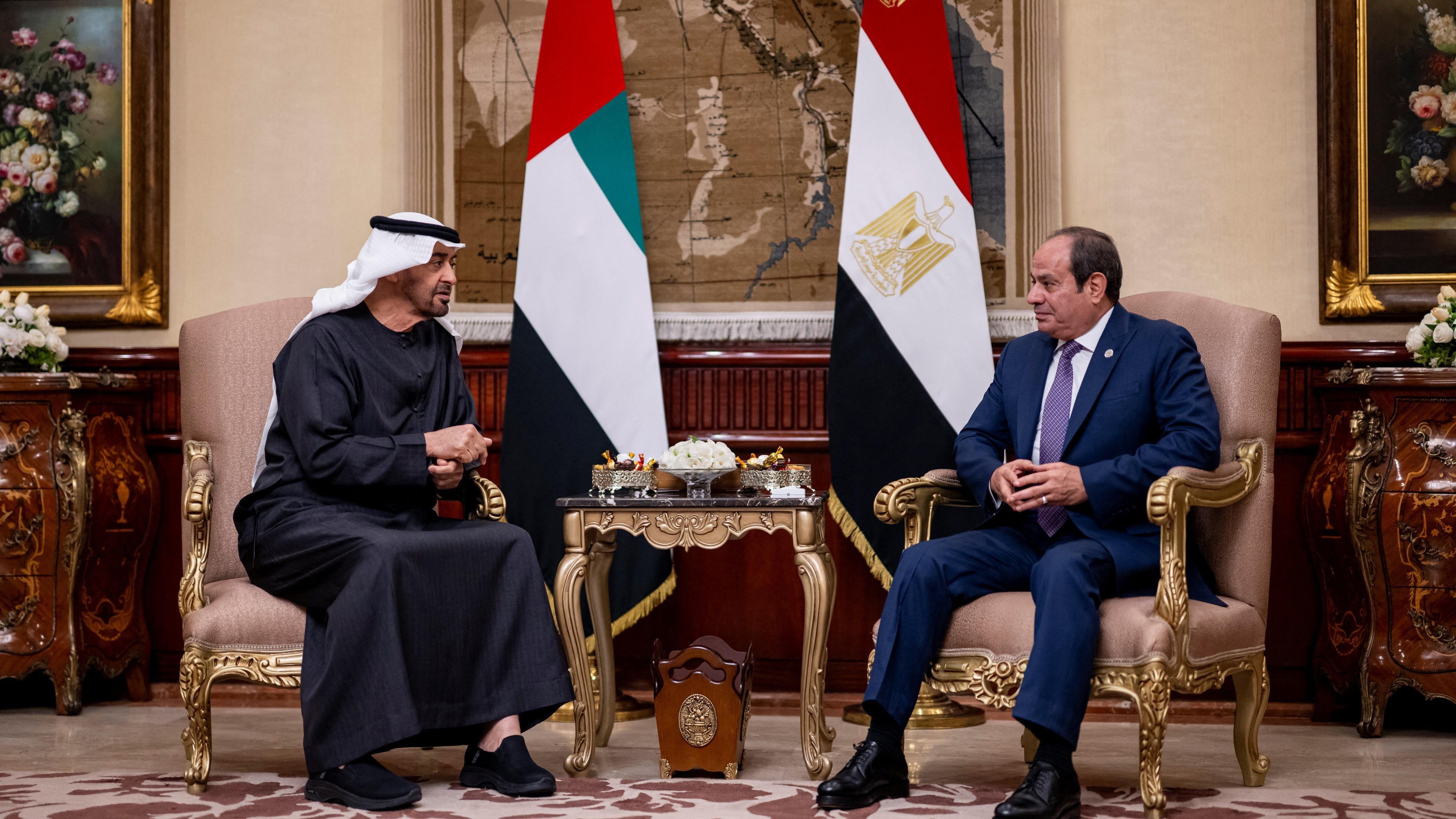 الرئيس المصري عبد الفتاح السيسي يجلس إلى جانب الرئيس الإماراتي الشيخ محمد بن زايد خلال استقبال الأخير في القاهرة وهما يجلسان على كرسيين منفصلين ويظهر خلفهما العلمان المصري والإماراتي. - Reuters