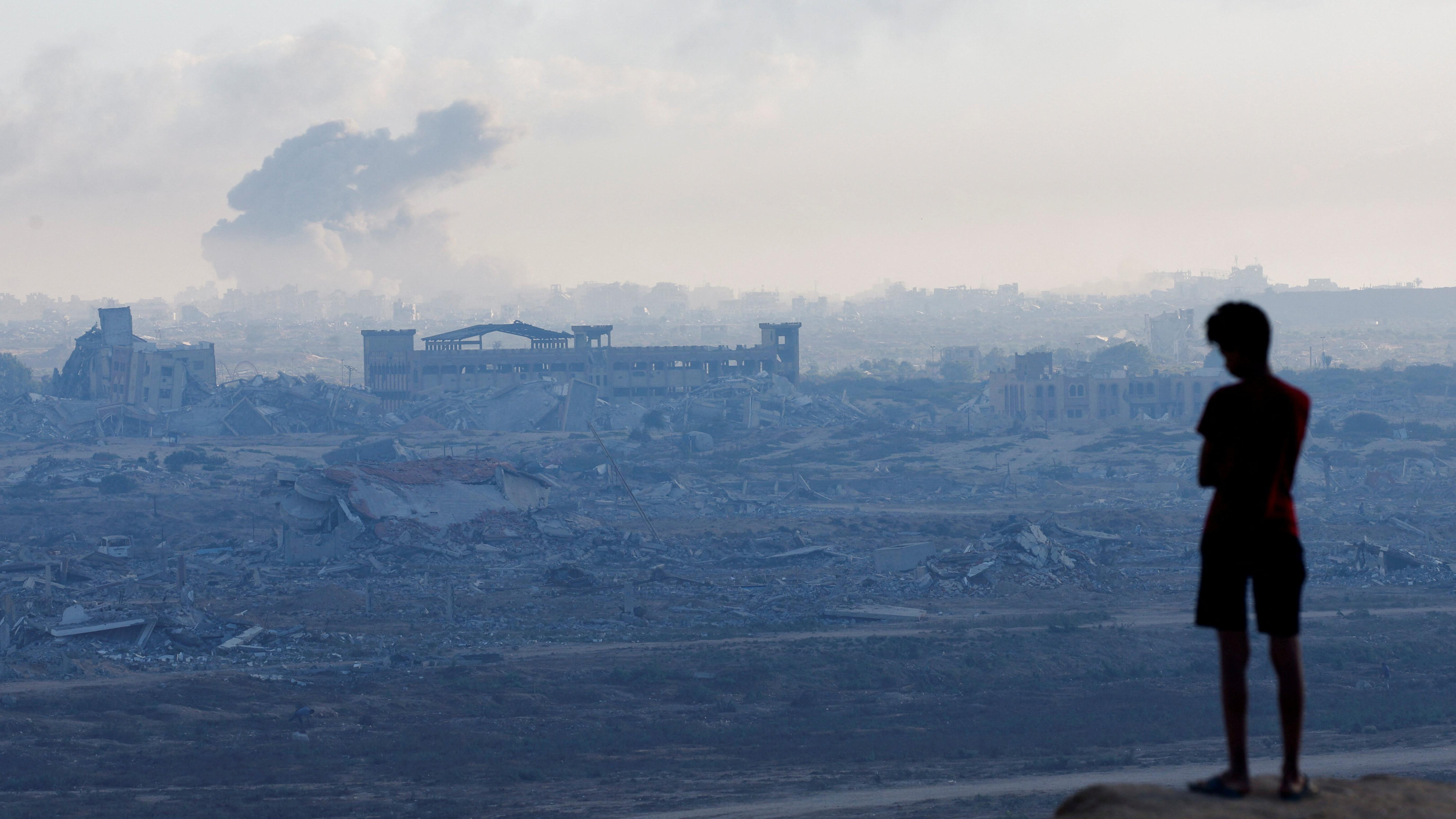 طفل غزي ينظر إلى دخان من قصف - Reuters