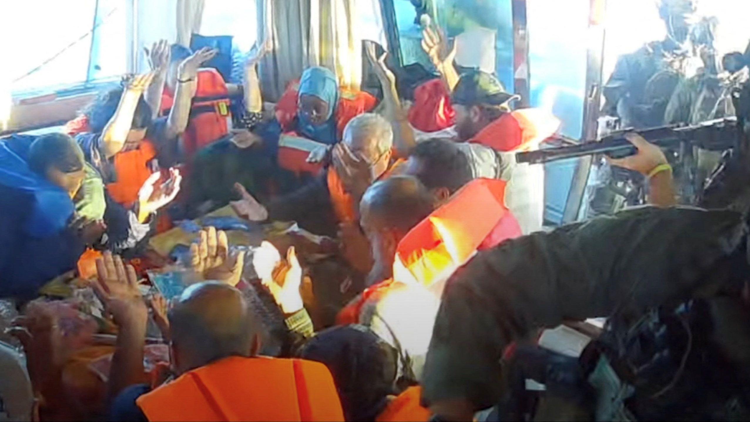 أفراد أسطول الصمود يرفعون أيديهم بعد أن صعدت قوات البحرية الإسرائيلية على متن سفينة 