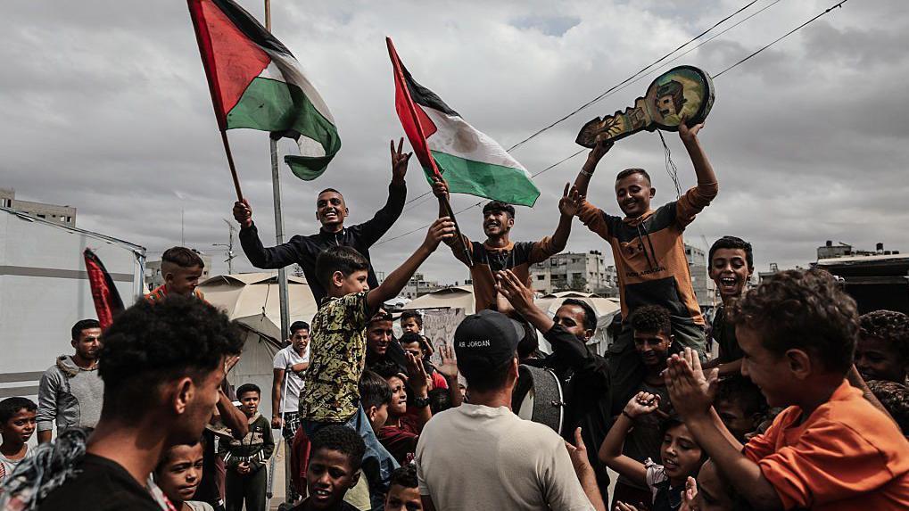 غزيون يرفعون الأعلام الفلسطينية ويحتلفون بإبرام المرحلة الأولى من وقف إطلاق النار بين إسرائيل وحماس - Getty Images