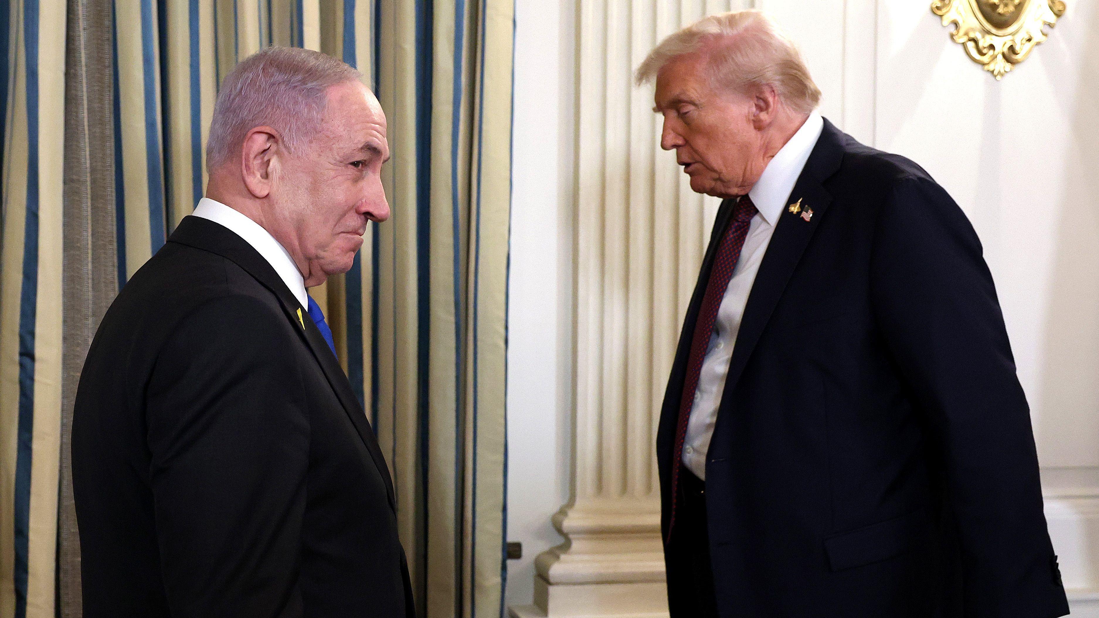 الرئيس الأمريكي دونالد ترامب يغادر قاعة شهدت مؤتمراً صحفياً مع رئيس الوزراء الإسرائيلي بنيامين نتنياهو الذي ما يبدو لا يزال واقفاً - Getty Images