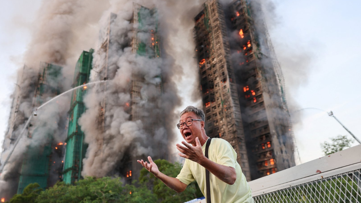 شخص يصرخ وفي الخلفية المجمع السكني أثناء الحريق - Reuters