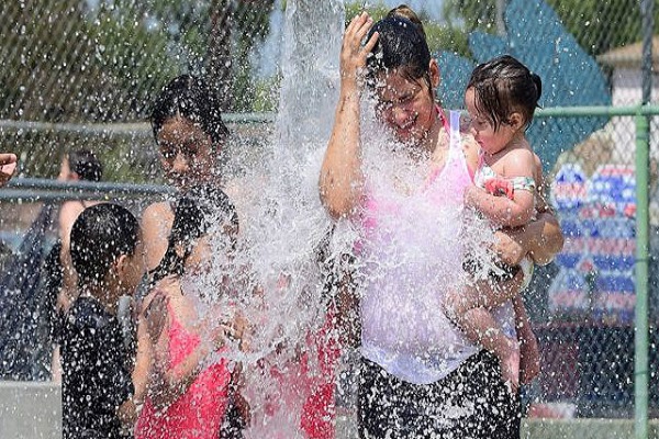 الأطفال يستخدمون المياه للتخفيف من الحرارة