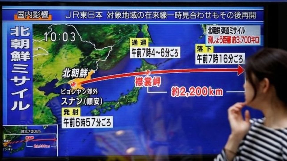 شابة يابانية تنظر إلى لقطة تلفزيونية توضح مسار الصاروخ الباليستي الذي أطلقته فوق جزيرة هوكايدو شمالي اليابان