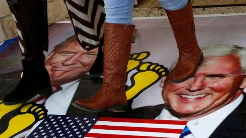فلسطينيون يسرون على ملصق عليه صورة ترامب ونائبه بينس خلال احتجاجات في ديسمبر