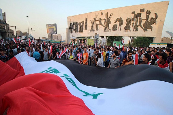 عراقيون يحملون علم بلادهم