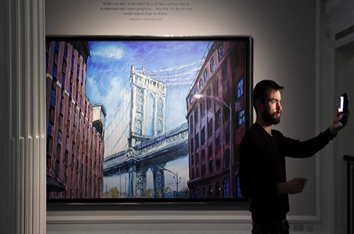 زائر يلتقط صورة (سيلفي) أمام إحدى لوحات ديلان