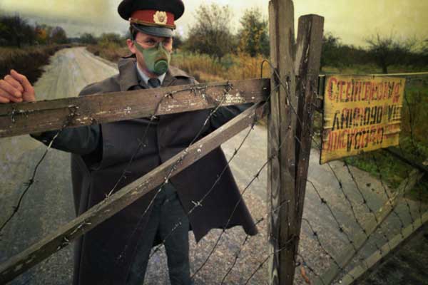 أحد أعضاء الميليشيا يضع علامة محظورة على سياج يقع داخل دائرة نصف قطرها تشيرنوبيل في حدود 30 كم في عام 1990