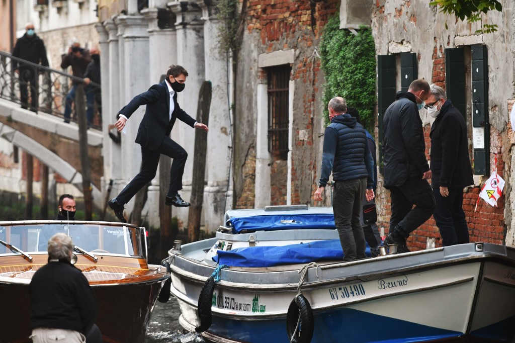 الممثل الأميركي توم كروز يقفز بين قاربين أثناء تصوير فيلم ميشن إمبوسيبل في مدينة البندقية في إيطاليا، 20 أكتوبر 2020. (أ ف ب)