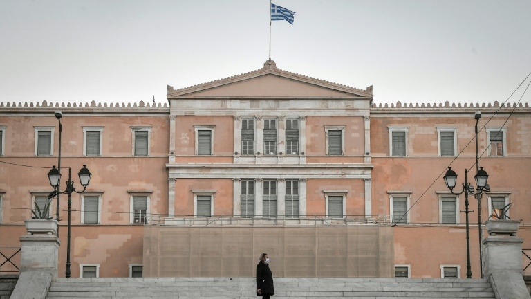 امرأة تمشي قرب البرلمان اليوناني في أثينا في الأول من ديسمبر 2020