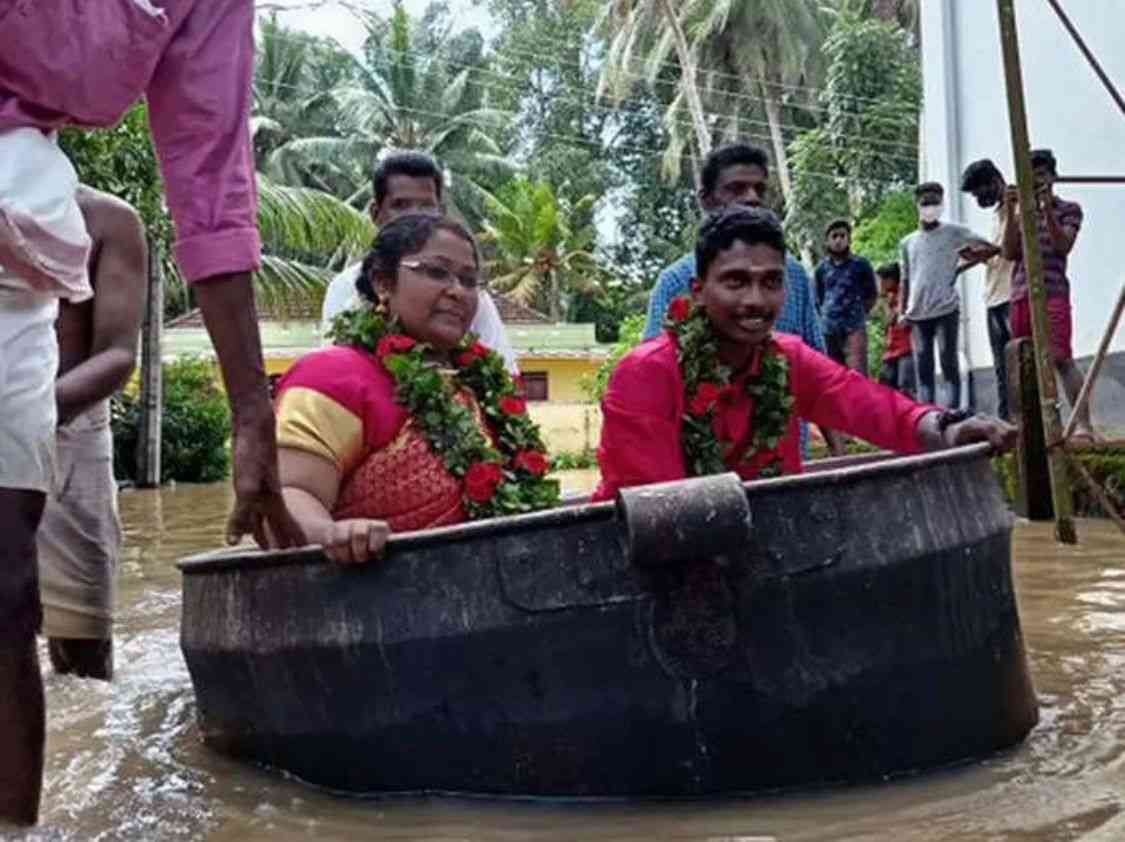 عروسان هنديان يستقلان إناء طهي عملاقا إلى موقع زفافهما بسبب الفيضانات