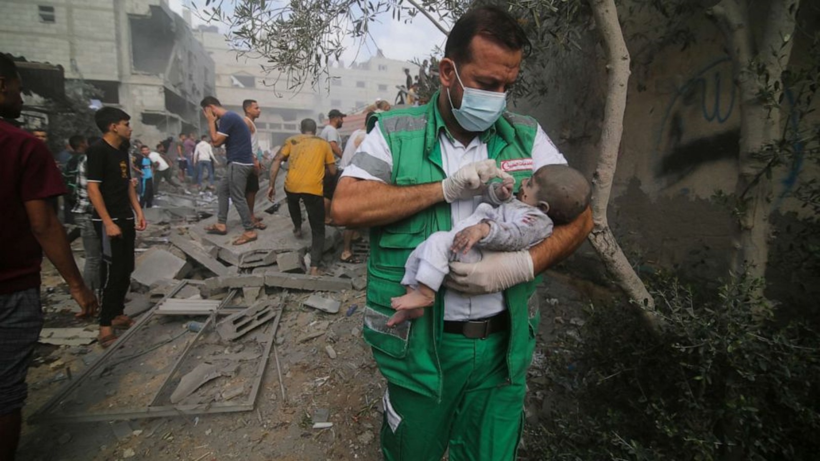 مسعف فلسطيني يحمل طفلاً تم انتشاله من المباني المدمرة في القصف الإسرائيلي لقطاع غزة في رفح، 22 أكتوبر 2023