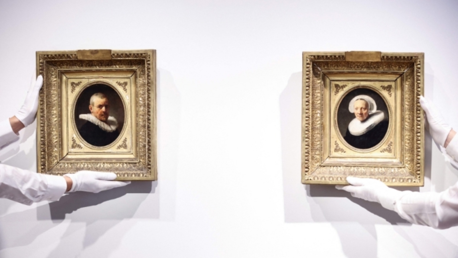 مساعدون في معرض يحملون لوحتين منسوبتين للفنان الهولندي رامبرانت قبل عرضهما في دار كريستيز للمزادات في أمستردام في 21 يونيو 2023