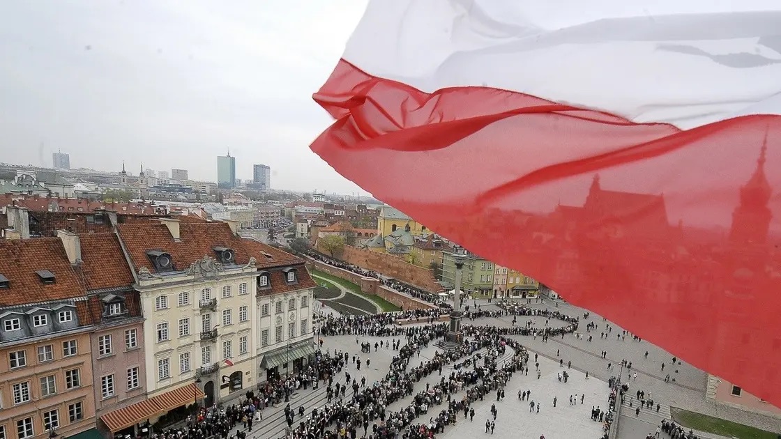 العلم البولندي وتبدو العاصمة البولندية وارسو في صورة من الأرشيف