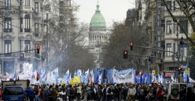 متظاهرون يقطعون جادة 9 يوليو في بوينوس أيرس احتجاجًا على حكومة الرئيس ماوريسيو ماكري، وفي الخلفية مبنى الكونغرس الأرجنتيني، في 12 سبتمبر 2018