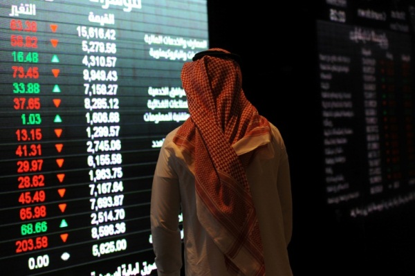 مستثمر سعودي يتابع أسعار الأسهم في البورصة بالرياض