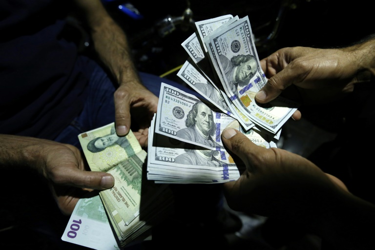 تبادل ريال إيراني مقابل دولار أميركي في محل صيرفة في طهران في 8 آب/أغسطس 2018