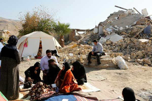 إيرانيون يجلسون أمام منازلهم المدمّرة في بلدة كويك بعد زلزال ضرب غرب البلاد بتاريخ 15 نوفمبر 2017