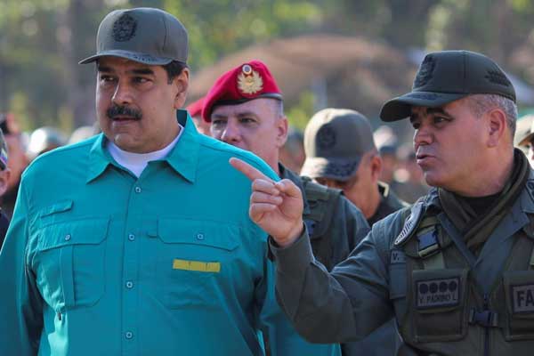 رئيس فنزويلا نيكولاس مادورو (يسار) يستمع إلى وزير دفاعه فلاديمير بادرينو خلال تدريبات عسكرية في ولاية كارابوبو في 27 يناير 2019