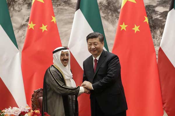 مصافحة بين الرئيس الصيني ونظيره أمير الكويت إثر توقيع الاتفاق