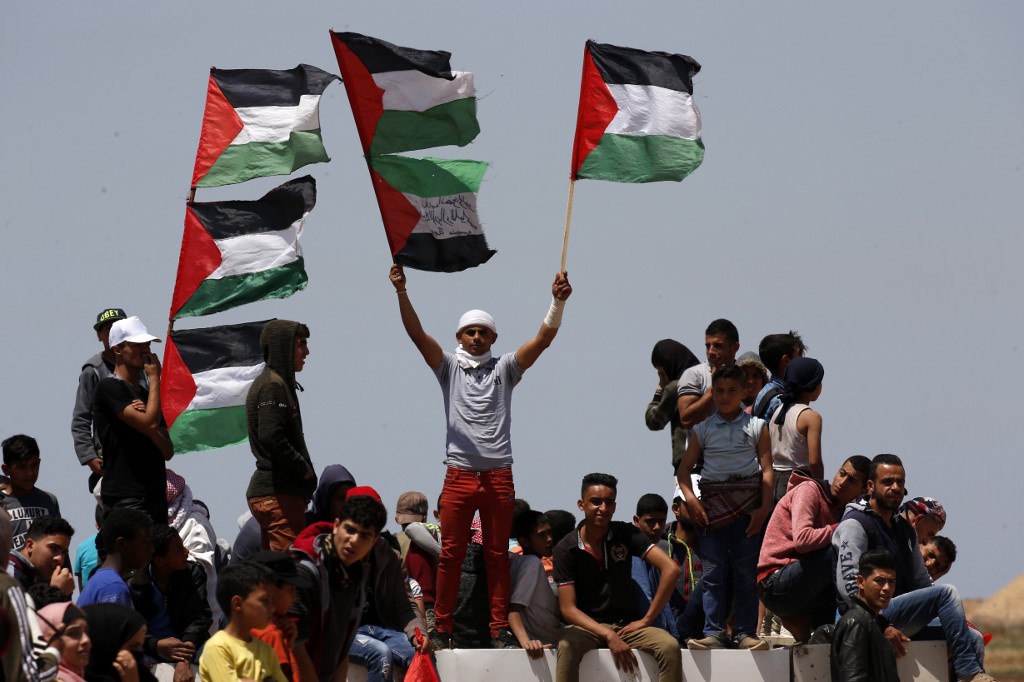 محتجون يرفعون الاعلام الفلسطينية على الحدود بين قطاع غزة وإسرائيل