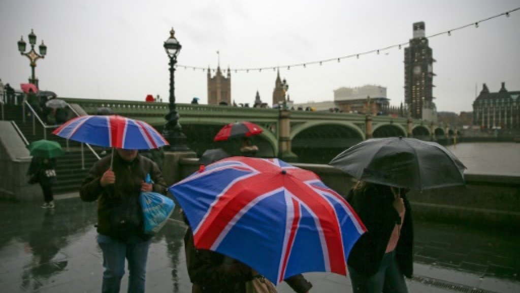 مارة يحتمون من المطر على الضفة الجنوبية لنهر تيمز قرب مجلس العموم البريطاني، في لندن في 11 كانون الأول/ديسمبر 2018 ا ف ب/ارشيف