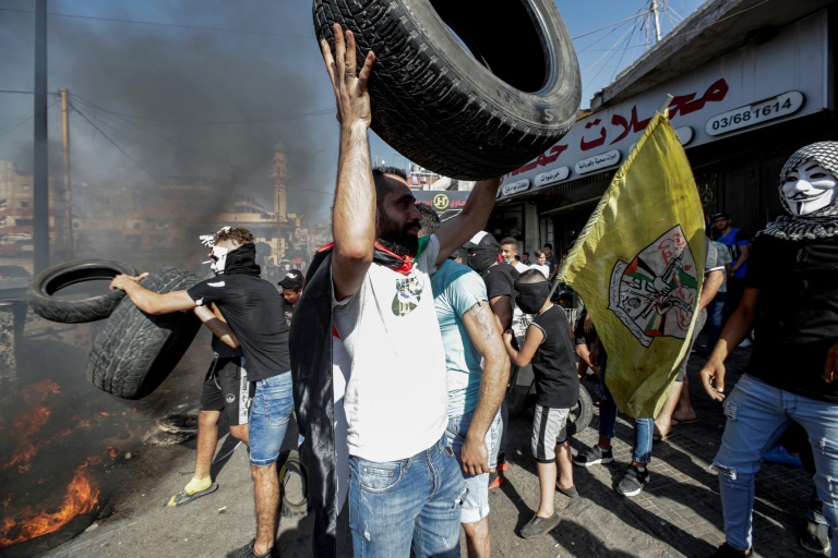 محتجون فلسطينيون يحرقون اطارات في مخيم برج البراجنة للاجئين جنوب بيروت في 16 يوليو 2019