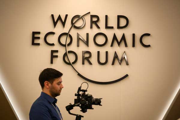 مصور أمام شعار المنتدى الاقتصادي العالمي في دافوس في اجتماعه السنوي في 20 يناير 2019