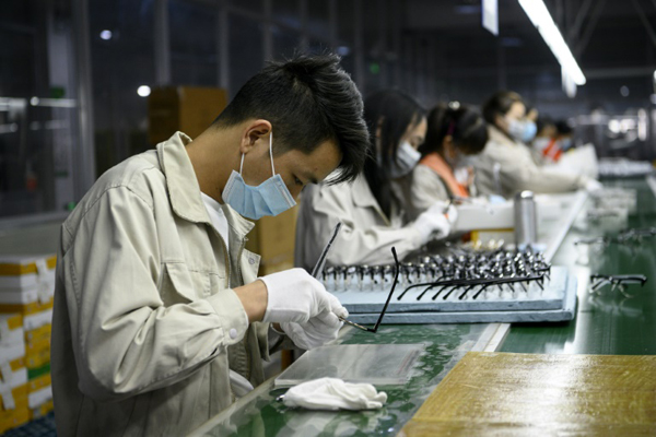 عمال يضعون أقنعة واقية في مصنع نظارات لشركة 