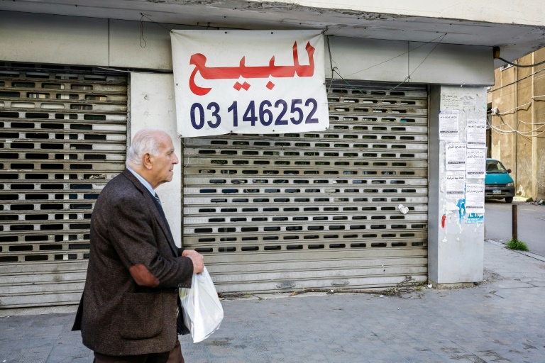 رجل يمر أمام محل معروض للبيع في طرابلس بشمال لبنان في 25 شباط/فبراير 2020.