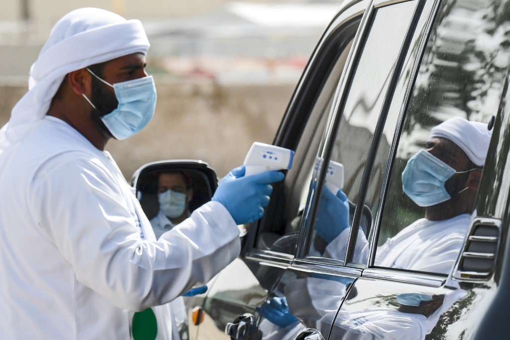 اطار صحي اماراتي يقوم بفحص سريع على مواطن داخل سيارته لتتبع اعراض كورونا