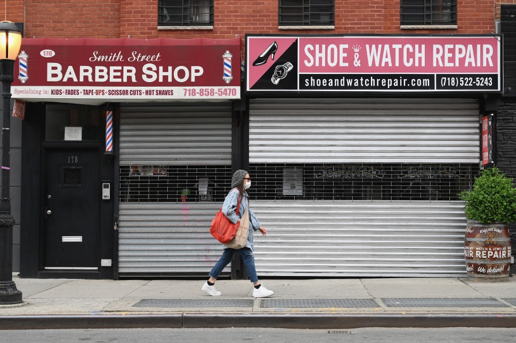 سيدة تمرّ أمام محلات مغلقة في نيويورك التي تفشى فيها فيروس كورونا