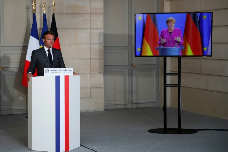 الرئيس الفرنسي إيمانويل ماكرون يستمع إلى المستشارة الألمانية أنغيلا ميركل أثناء مؤتمر صحافي عبر الفيديو