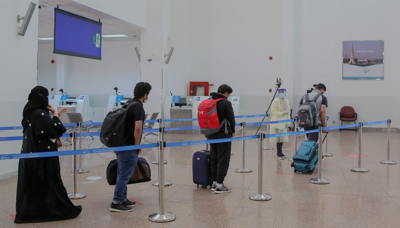 مسافرون في مطار الملك عبدالعزيز يحترمون ضوابط التباعد الجسدي