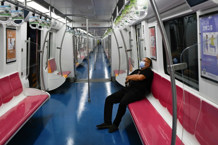 راكب يضع كمامة خلال استخدامه قطار الأنفاق في بكين
