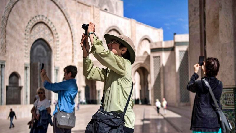 سياح يلتقطون صوراً لمسجد الحسن الثاني في الدار البيضاء في المغرب. مارس 2020