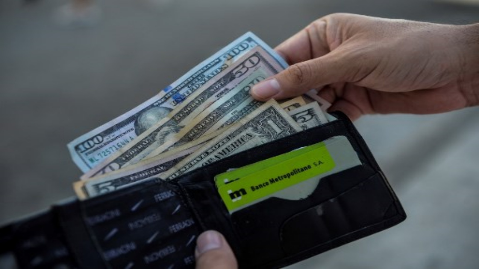 رجل يعرض محفظته بالدولار الأمريكي في أحد شوارع هافانا ، في 15 سبتمبر 2020. مع عودة الدولار إلى اقتصاد الجزيرة ، لا أحد يريد البيزو الكوبي القابل للتحويل (CUC)